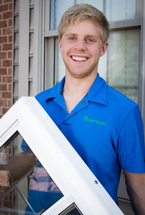 Man in blue shirt carrying a white window frame