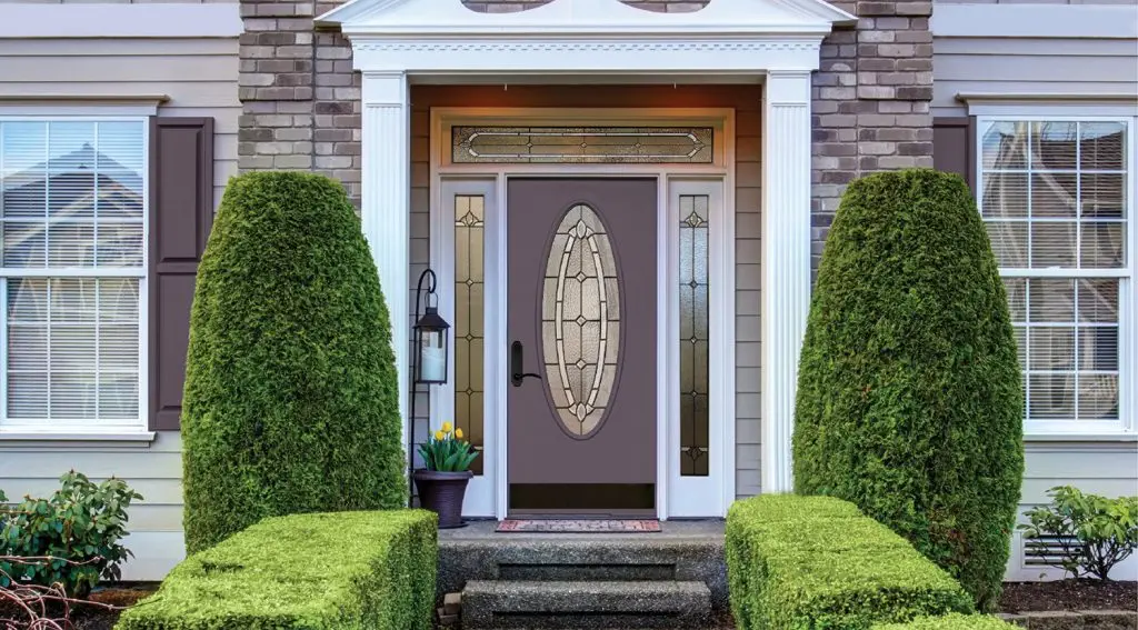 A residence with an entry door and bushes.